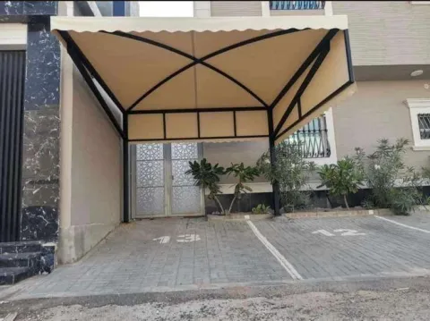 Car parking shade installation in the UAE showing steel frame and canopy fitting